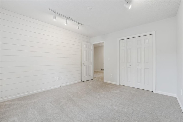 2986 Edenberry Ln NW, Kennesaw, GA 30152 - unfurnished bedroom with track lighting, carpet flooring, wooden walls, a closet, and baseboards