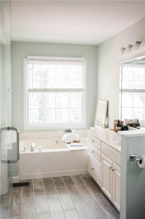 2986 Edenberry Ln NW, Kennesaw, GA 30152 - bathroom with wood finish floors, plenty of natural light, a bath, and vanity
