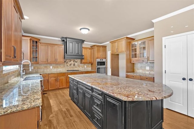 17 River Walk Pkwy, Euharlee, GA 30145 - kitchen featuring gas cooktop, a sink, stainless steel double oven, backsplash, and dark cabinetry