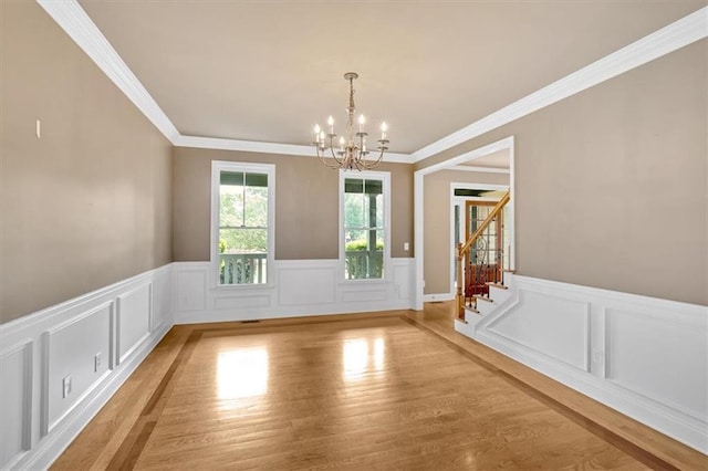 17 River Walk Pkwy, Euharlee, GA 30145 - unfurnished dining area featuring a chandelier, wainscoting, stairs, crown molding, and light wood-style flooring