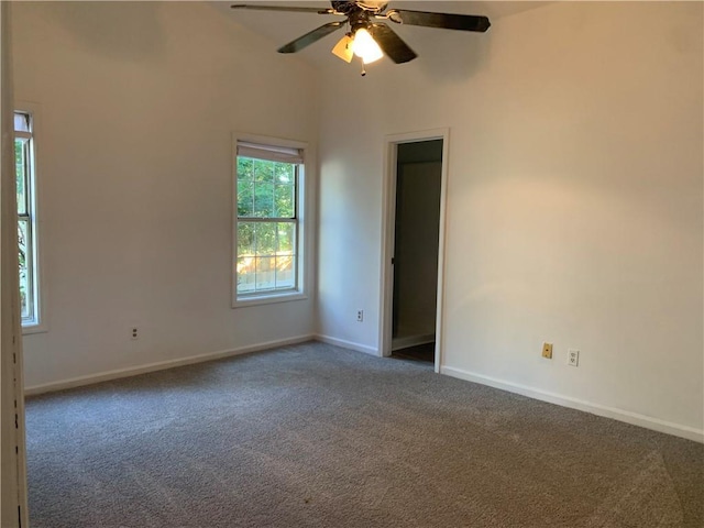 spare room featuring ceiling fan and dark colored carpet