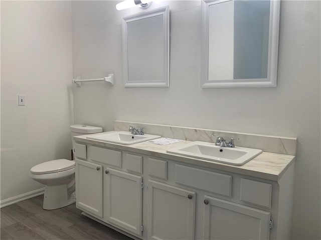 bathroom with hardwood / wood-style flooring, vanity, and toilet