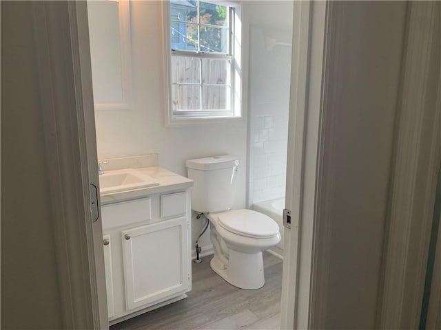 full bathroom with vanity, toilet, wood-type flooring, and bathing tub / shower combination