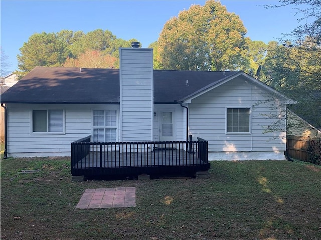 rear view of house with a deck and a lawn