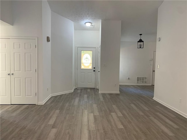 entryway with dark wood-type flooring and a textured ceiling