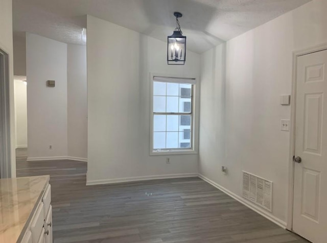 entryway with dark hardwood / wood-style flooring, a chandelier, and a textured ceiling