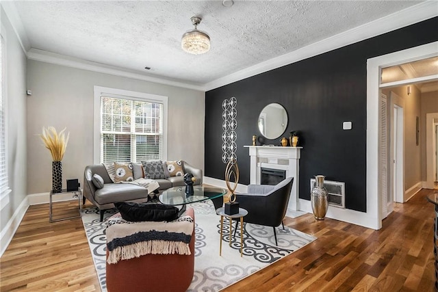 living room with wood-type flooring, a textured ceiling, heating unit, and ornamental molding