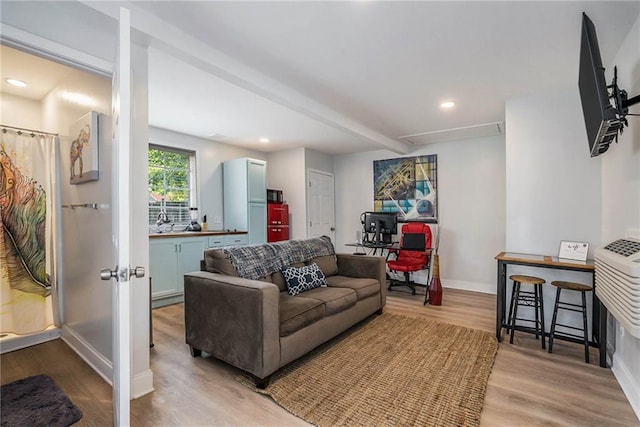 living room with beamed ceiling and light hardwood / wood-style flooring