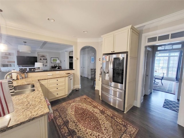 kitchen featuring a sink, stainless steel fridge, arched walkways, and crown molding