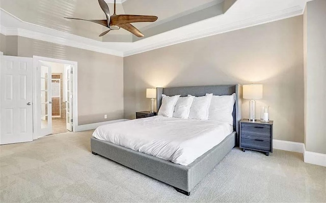 bedroom featuring baseboards, ensuite bath, crown molding, a raised ceiling, and carpet flooring