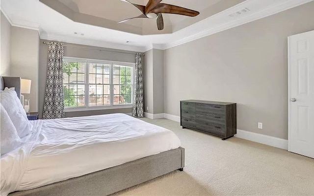 bedroom with crown molding, a raised ceiling, baseboards, and carpet floors