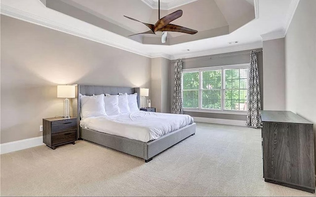 carpeted bedroom featuring ceiling fan, baseboards, a raised ceiling, and ornamental molding