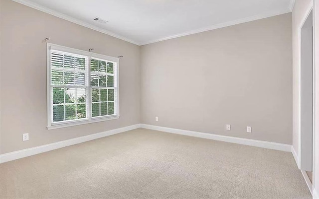 empty room featuring crown molding, light colored carpet, and baseboards