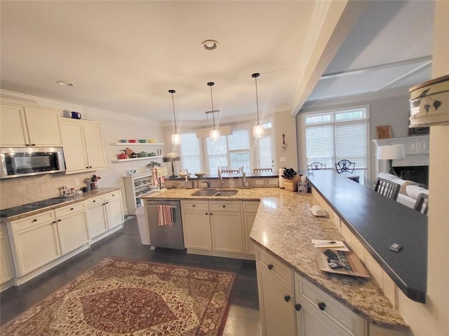 kitchen with decorative backsplash, ornamental molding, appliances with stainless steel finishes, and a sink