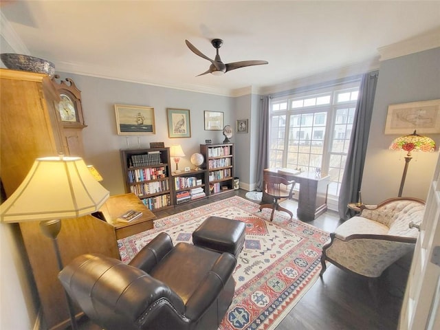 living area with baseboards, crown molding, ceiling fan, and wood finished floors