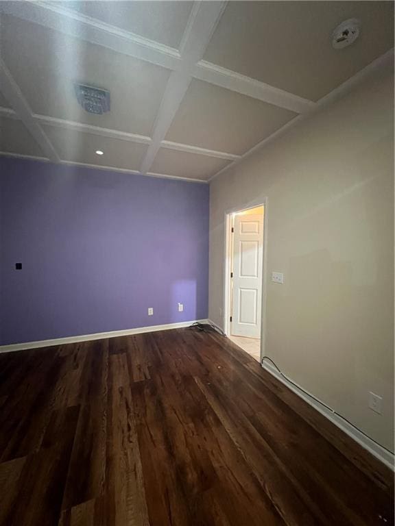 spare room featuring baseboards, coffered ceiling, and wood finished floors