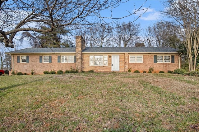 single story home with brick siding, a chimney, and a front lawn