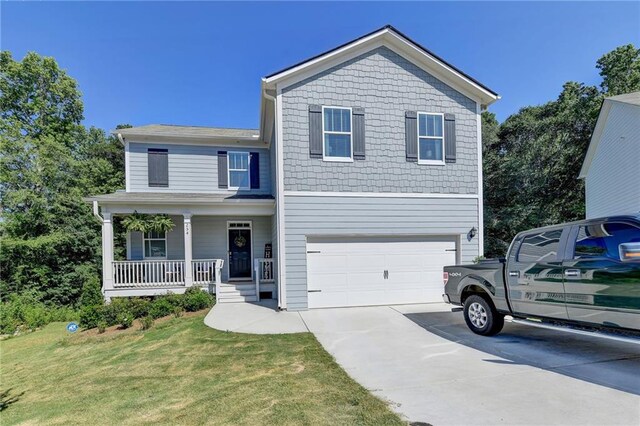 view of front of house featuring covered porch, a garage, and a front yard