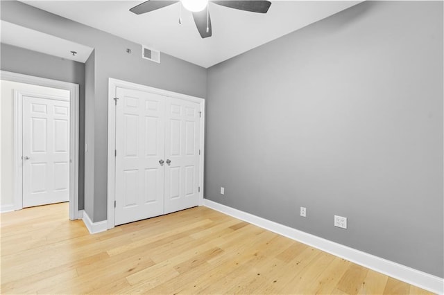 unfurnished bedroom featuring hardwood / wood-style floors, ceiling fan, and a closet