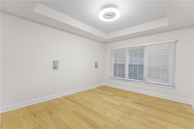 unfurnished room featuring hardwood / wood-style floors and a raised ceiling