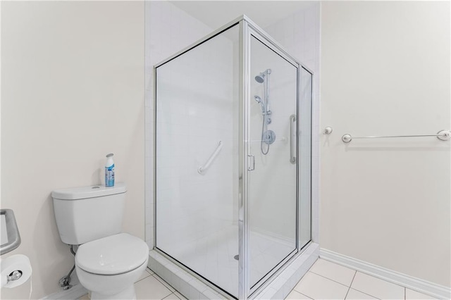 bathroom featuring a shower with shower door, tile patterned floors, and toilet