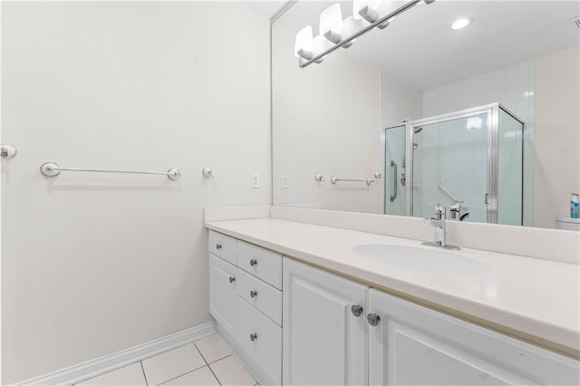 bathroom with tile patterned floors, a shower with shower door, and vanity