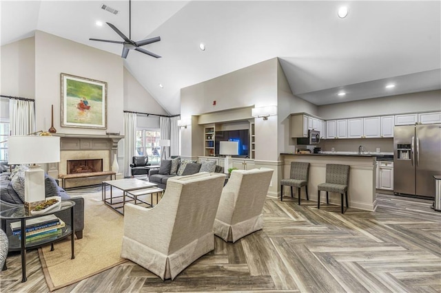 living room with ceiling fan, high vaulted ceiling, and light parquet floors