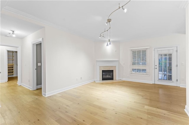 unfurnished living room with ornamental molding and light hardwood / wood-style floors