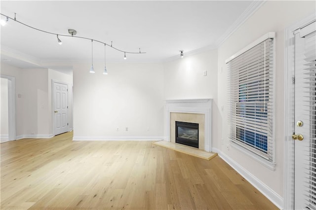 unfurnished living room featuring crown molding, a fireplace, and light hardwood / wood-style flooring