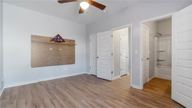 unfurnished bedroom featuring ensuite bath, ceiling fan, and light wood-type flooring