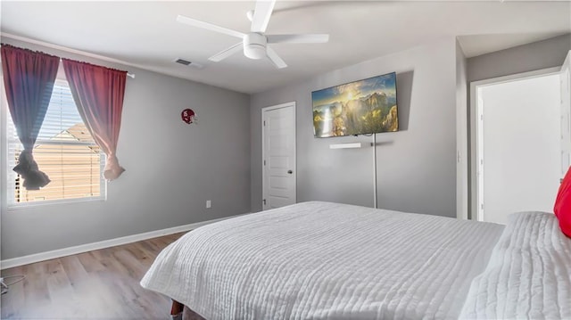 bedroom with multiple windows, ceiling fan, and light hardwood / wood-style floors