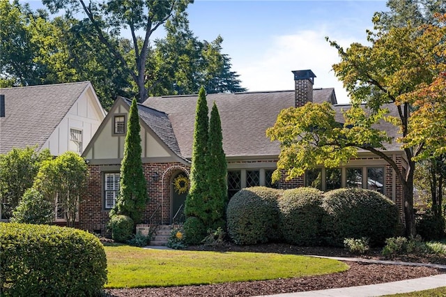 tudor home with a front lawn