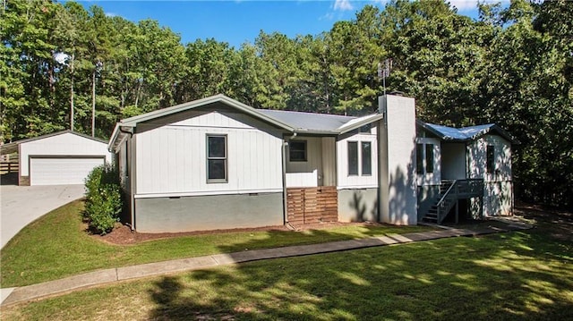 view of front facade with a garage, an outdoor structure, and a front yard