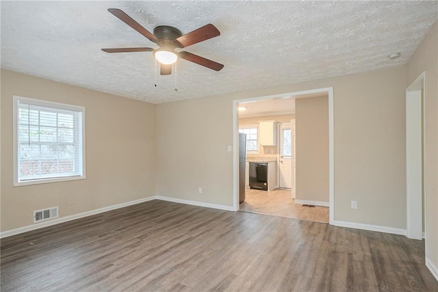 empty room featuring hardwood / wood-style floors, a textured ceiling, and ceiling fan