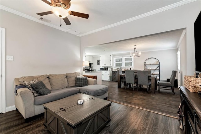 living room featuring visible vents, plenty of natural light, dark wood-style flooring, crown molding, and ceiling fan with notable chandelier