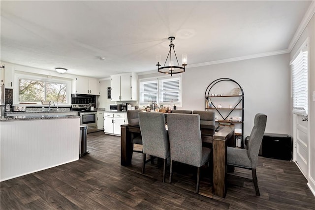 dining space featuring ornamental molding, a notable chandelier, dark wood-style floors, and a healthy amount of sunlight