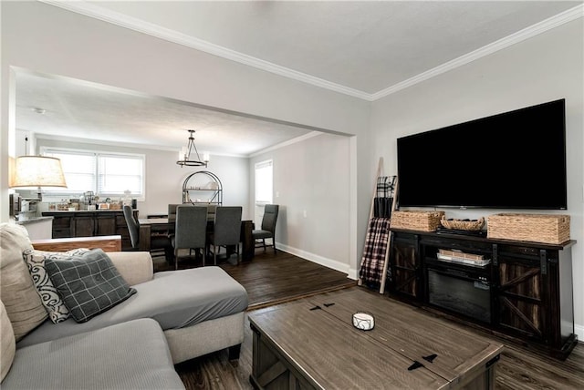 living room with plenty of natural light, ornamental molding, baseboards, and dark wood-style flooring