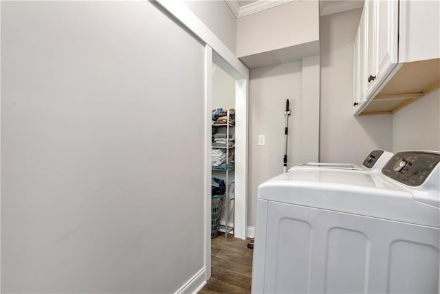 washroom with washing machine and clothes dryer, crown molding, dark wood-type flooring, baseboards, and cabinet space