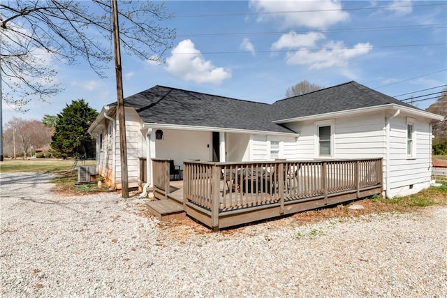 rear view of house featuring crawl space, a deck, and a shingled roof