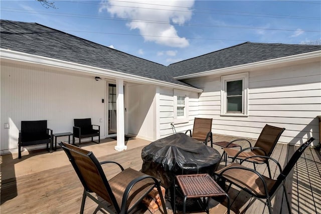 wooden deck with outdoor dining area and grilling area