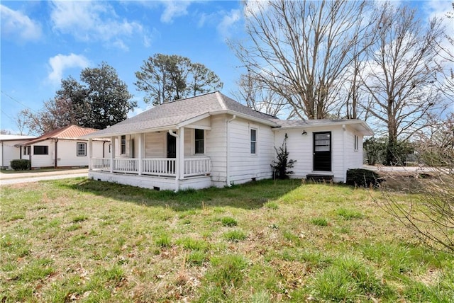 view of front of property with covered porch, a shingled roof, and a front yard