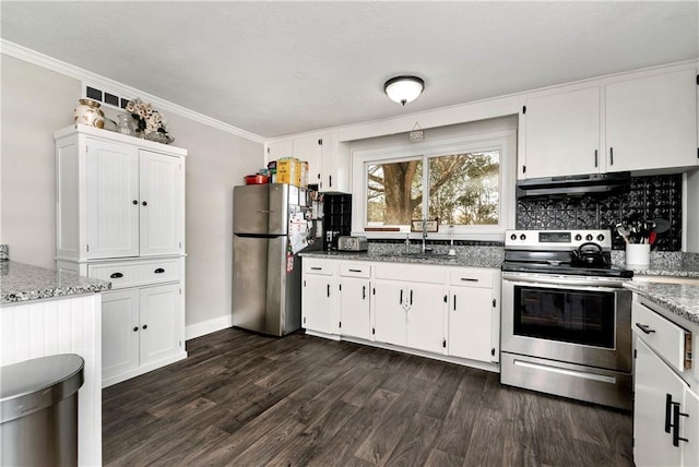 kitchen with under cabinet range hood, light stone counters, dark wood finished floors, stainless steel appliances, and white cabinets