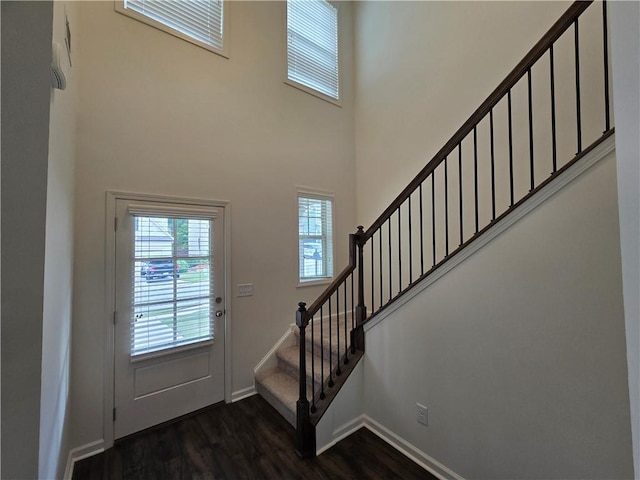 5521 Shallow Branch Dr, Flowery Branch, GA 30542 - foyer entrance featuring dark wood-style flooring, stairs, a high ceiling, and baseboards