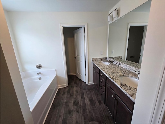 5521 Shallow Branch Dr, Flowery Branch, GA 30542 - full bathroom featuring double vanity, wood finished floors, a bath, and baseboards
