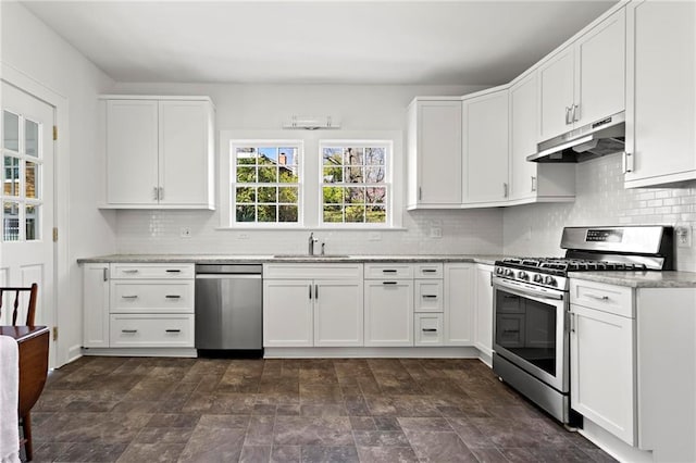 kitchen with a sink, stainless steel appliances, under cabinet range hood, white cabinetry, and tasteful backsplash