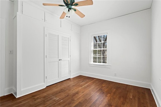 unfurnished bedroom with a closet, baseboards, ceiling fan, and dark wood-style flooring