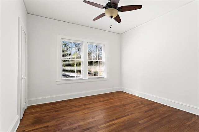 spare room featuring ceiling fan, baseboards, and dark wood finished floors