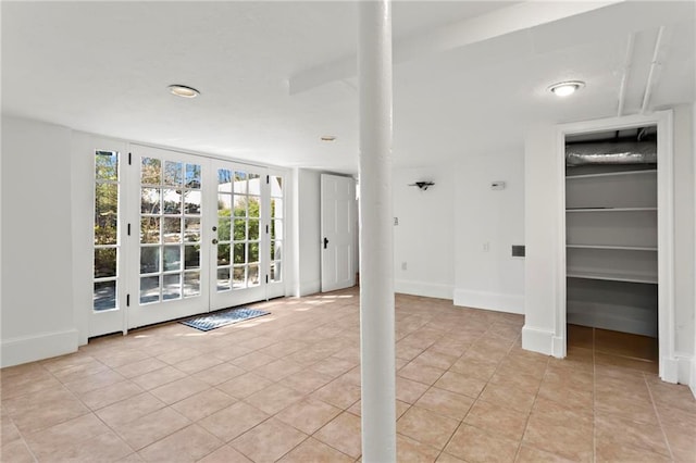 interior space featuring light tile patterned floors, french doors, and baseboards