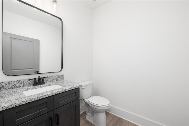 bathroom featuring vanity, hardwood / wood-style floors, and toilet