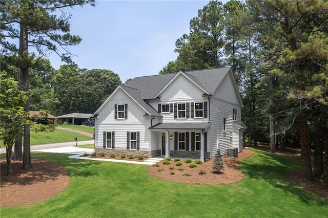 view of front facade with covered porch, a front yard, and cooling unit